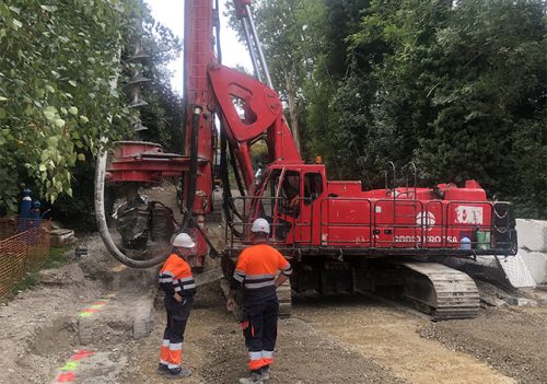 Dos trabajadores de Rodio Kronsa al costado de una máquina pilotadora.